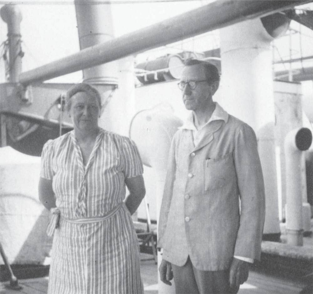 Black and white photograph of Alexander and Annie Mackie standing on the deck of the SS Jervis Bay. Annie wears a striped dress and Alexander wears a white shirt and a light coloured jacket.
