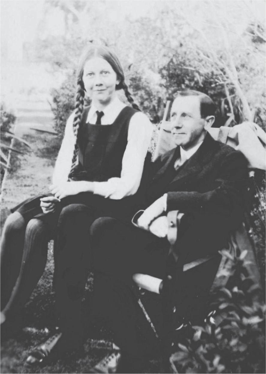 Black and white photograph of Alexander and Margaret Mackie sitting side-by-side. Margaret wears her school uniform: a white shirt with a tie and a dark-coloured dress.
