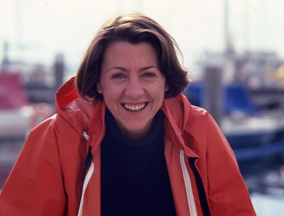 Photograph of a woman with brown hair, wearing a red jacket.