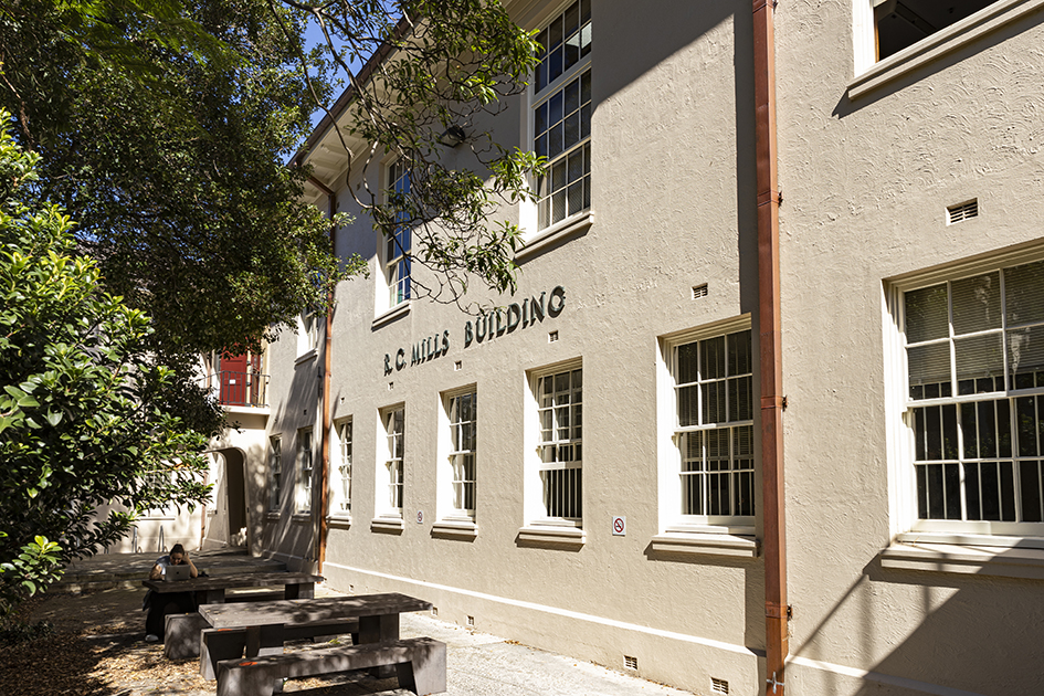 Photograph of a rendered brick building with white window frames.