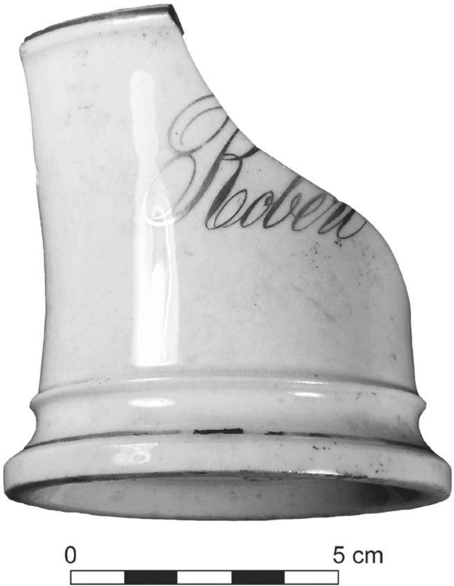 A black and white photograph of a broken mug. The name Robert is printed in a script style.