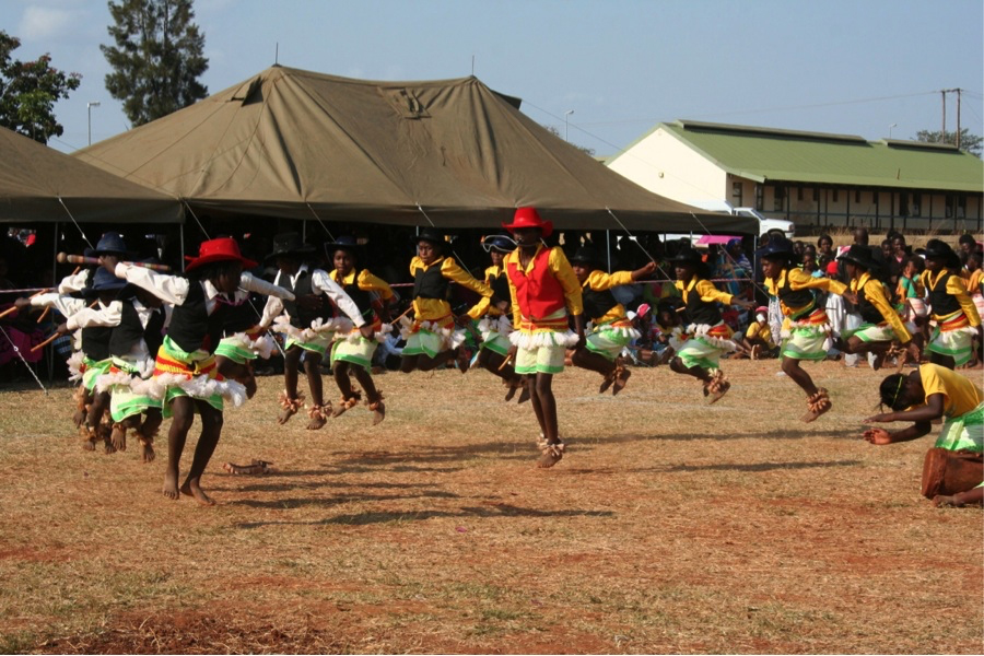 Figure 7.7. A colour photograph shows about 15 girls dancing. They are all jumping in the air at once while many people watch on.