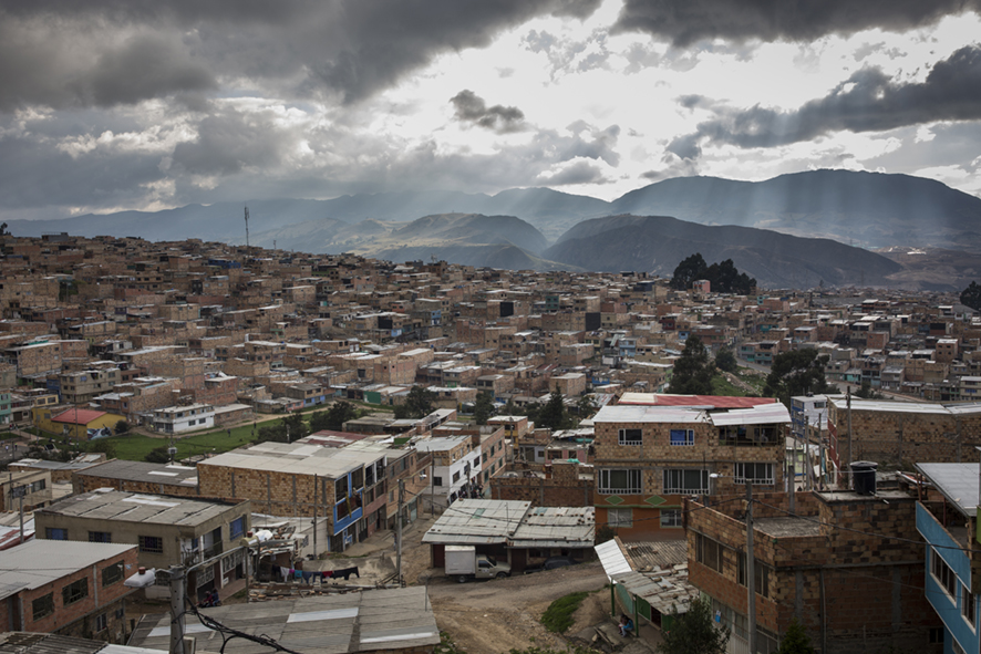 View of Bogota, Colombia, from high point in the city. Sky is bright with sunshine beaming through the clouds onto the city.