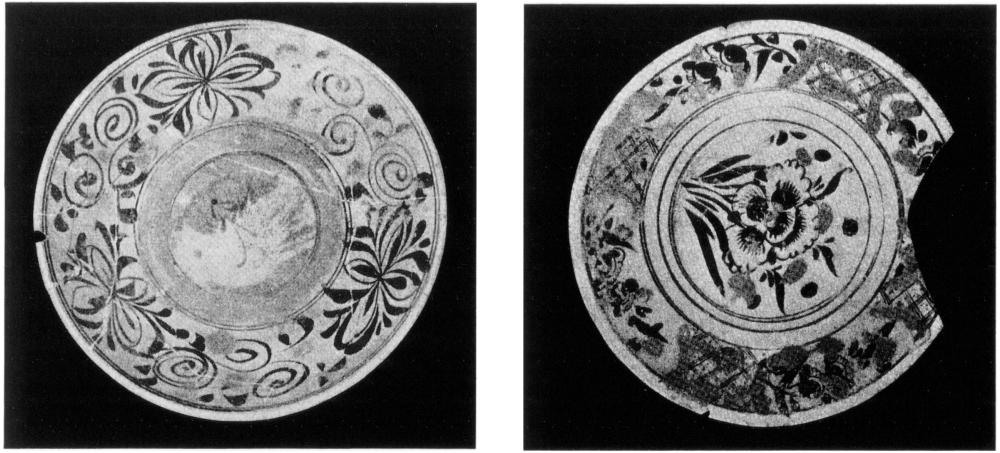 Two black-and-white photos of circular Chinese plates adorned with floral patterns on the brim. The photo on the left is slightly chipped on its left, with faintly visible crack marks around. The middle of plate appears to have a vague illustration. The right photo depicts the second plate, also circular in shape with a couple of small chips on the edges and notable chunk missing on the right side. It also has floral pattern on the edges but of a different kind to the first plate, with zig-zag patches at each quarterly point, and bordered by solid ring lines with two smaller rings towards the centre of the plate, bordering a clear illustration of a flower angled at 90 degrees to the right, supported by several stem-like figures and three circles dotted evenly above the flower. 