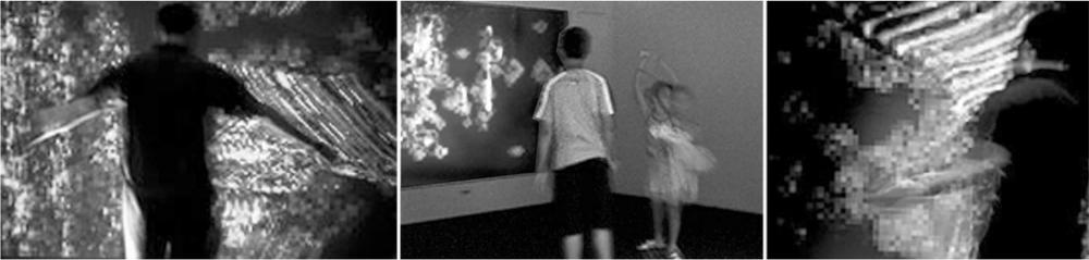 Black and white photographs of people walking in front of and interacting with installations responding to direction and rapidity of motion.