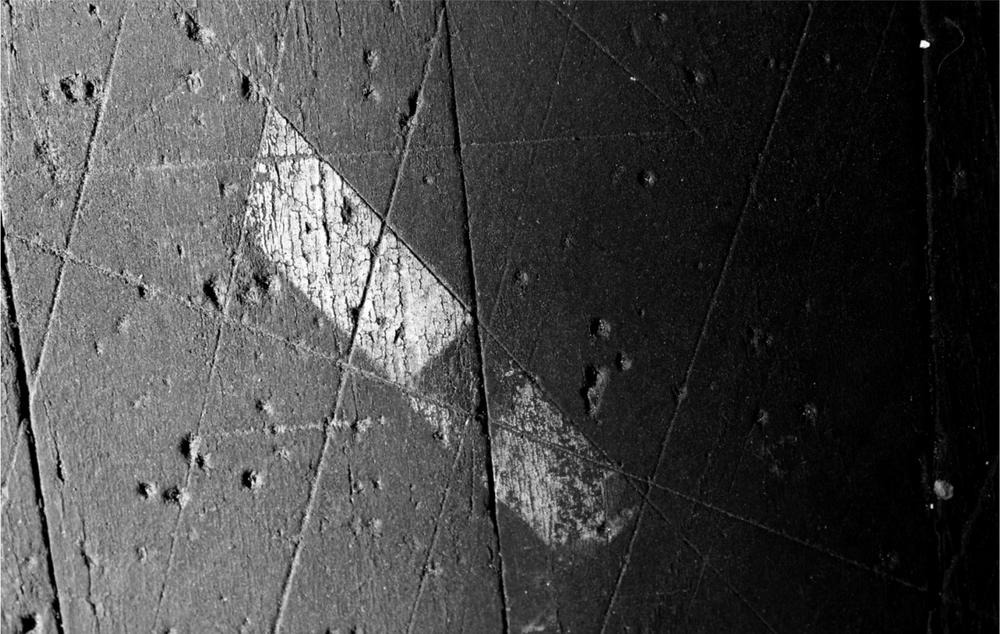 A black and white photograph of a surface with a large white mark on it.