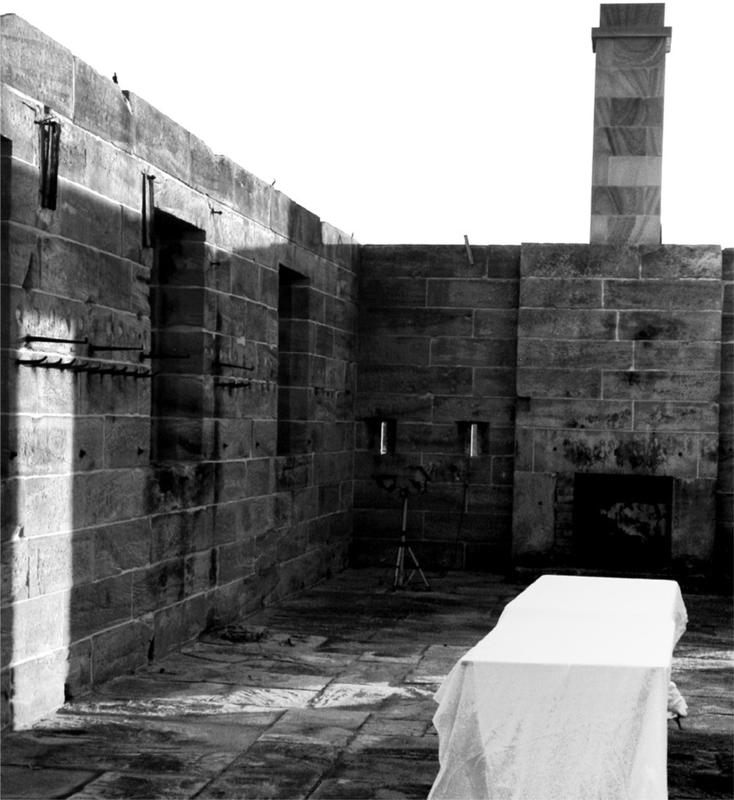 A black and white photograph of a sandstone building open area.