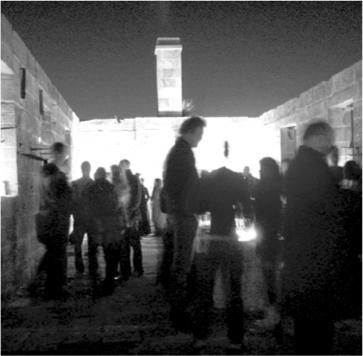 A black and white photograph of people standing in a large room.