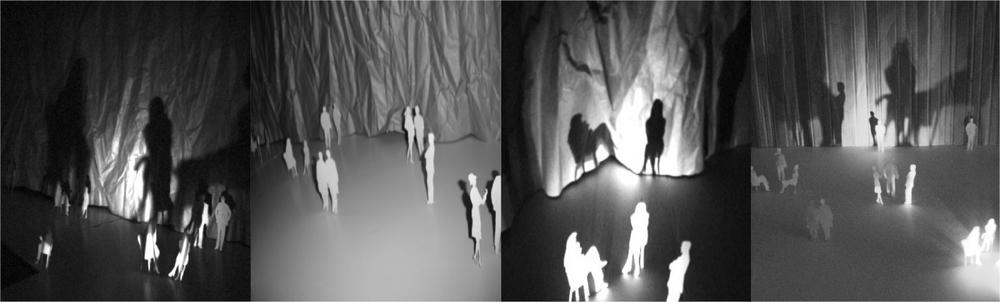 Four black and white images of people standing in a room of light installations.