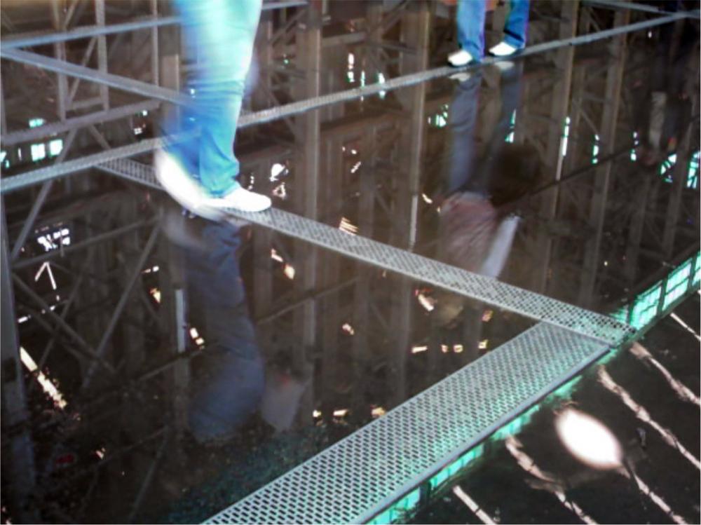 Images of people walking on beams in a room with water on the floor.