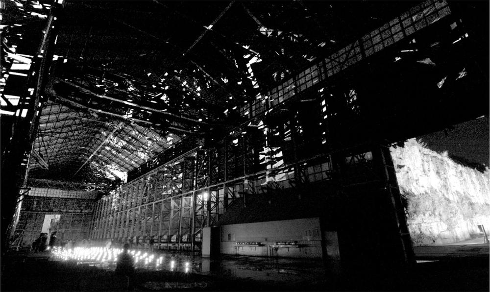 A large open room with exposed beams and a light installation on the floors.