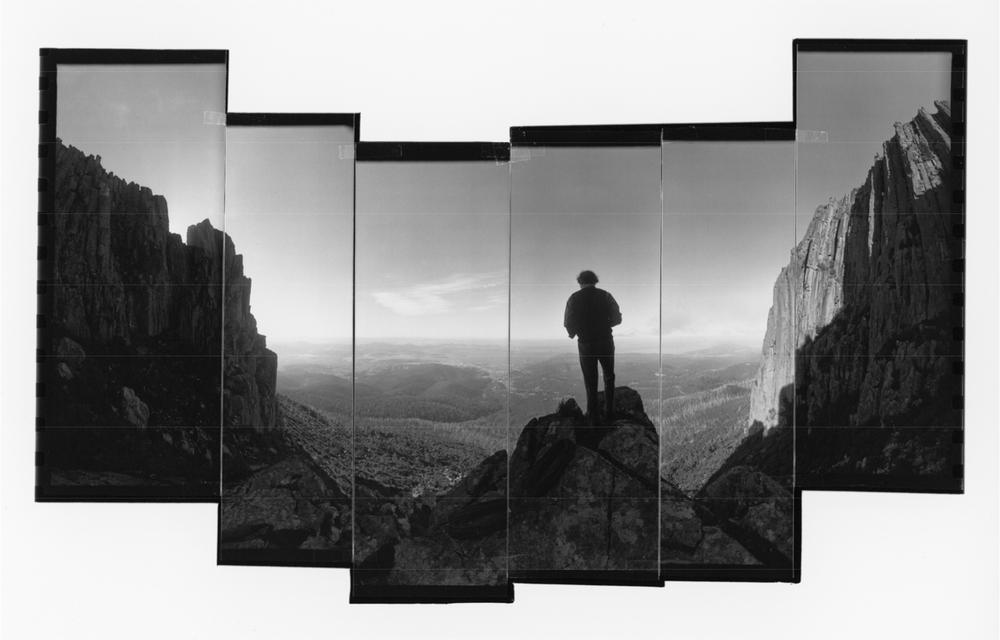 An artwork of a man standing on a rocky landscape and looking out over the horizon.