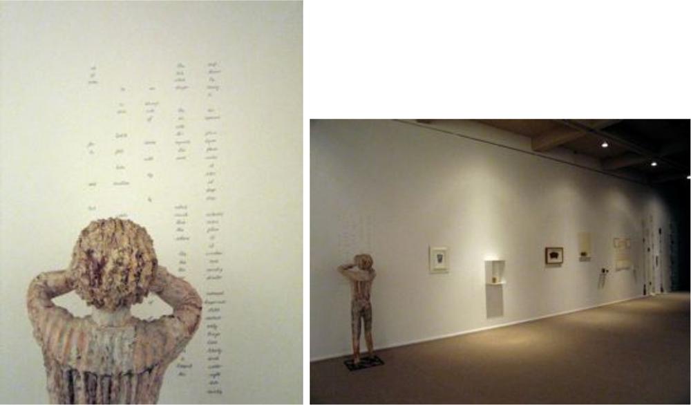 Images of a statue standing in a gallery and looking at the wall.