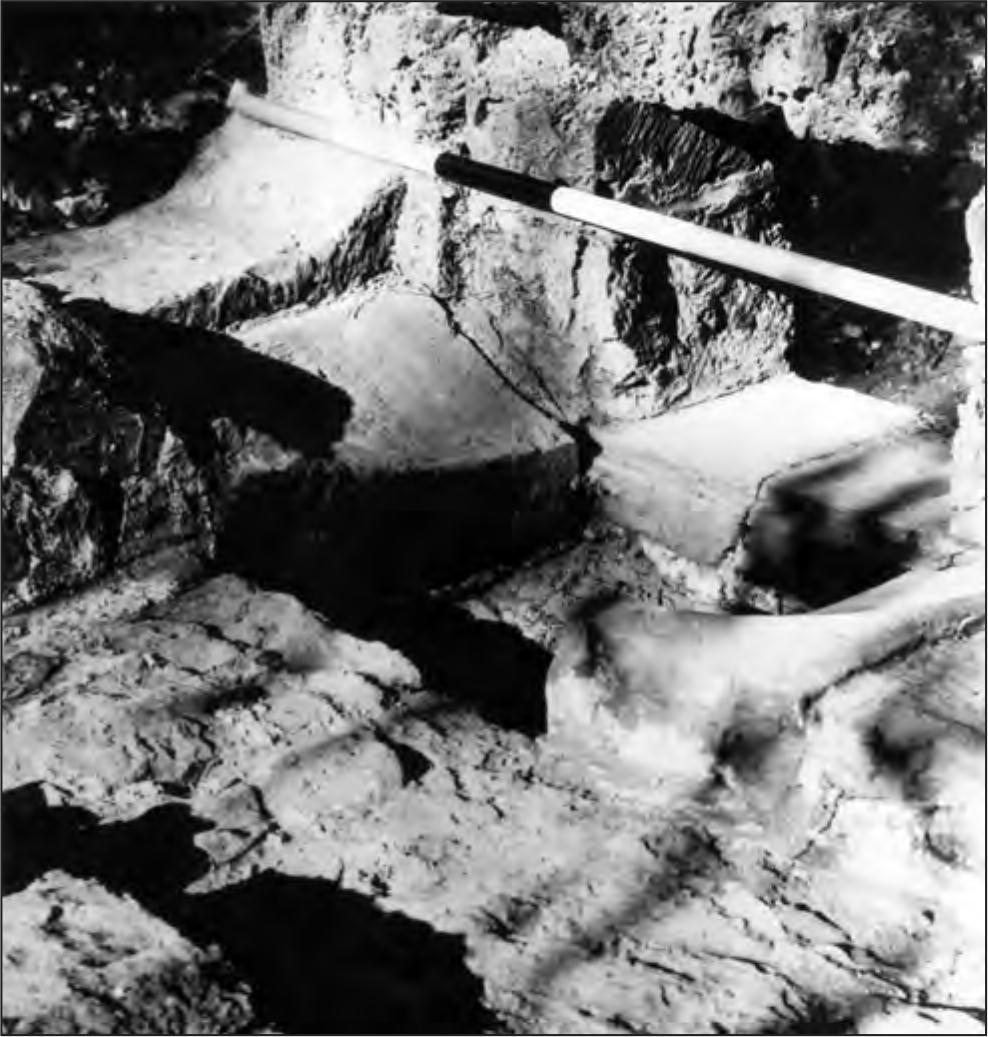 A black and white photograph of the forge area. A low square hole is situated on ground level.