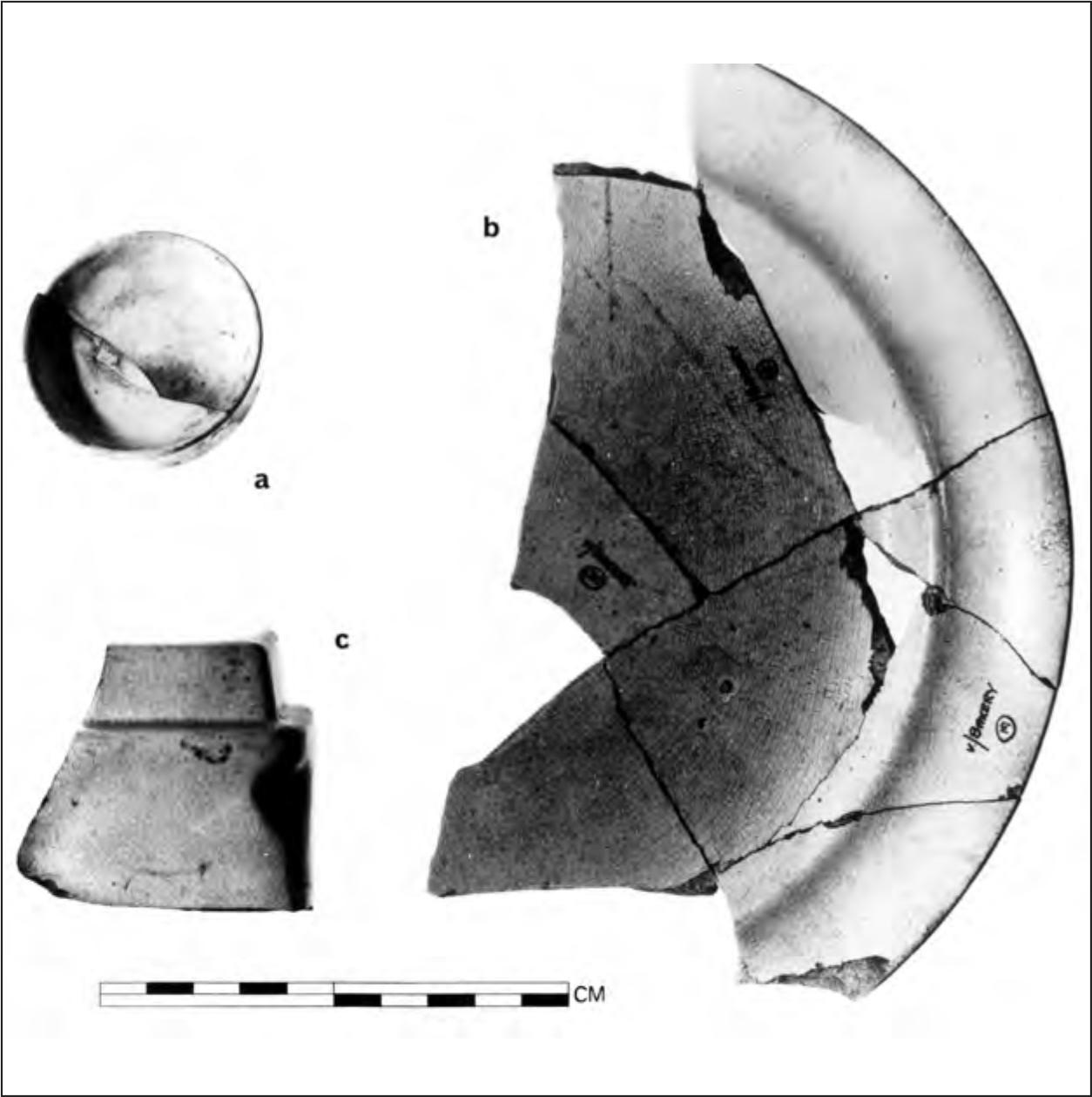 A black and white photograph of a fractured piece of pottery with no decoration. 
