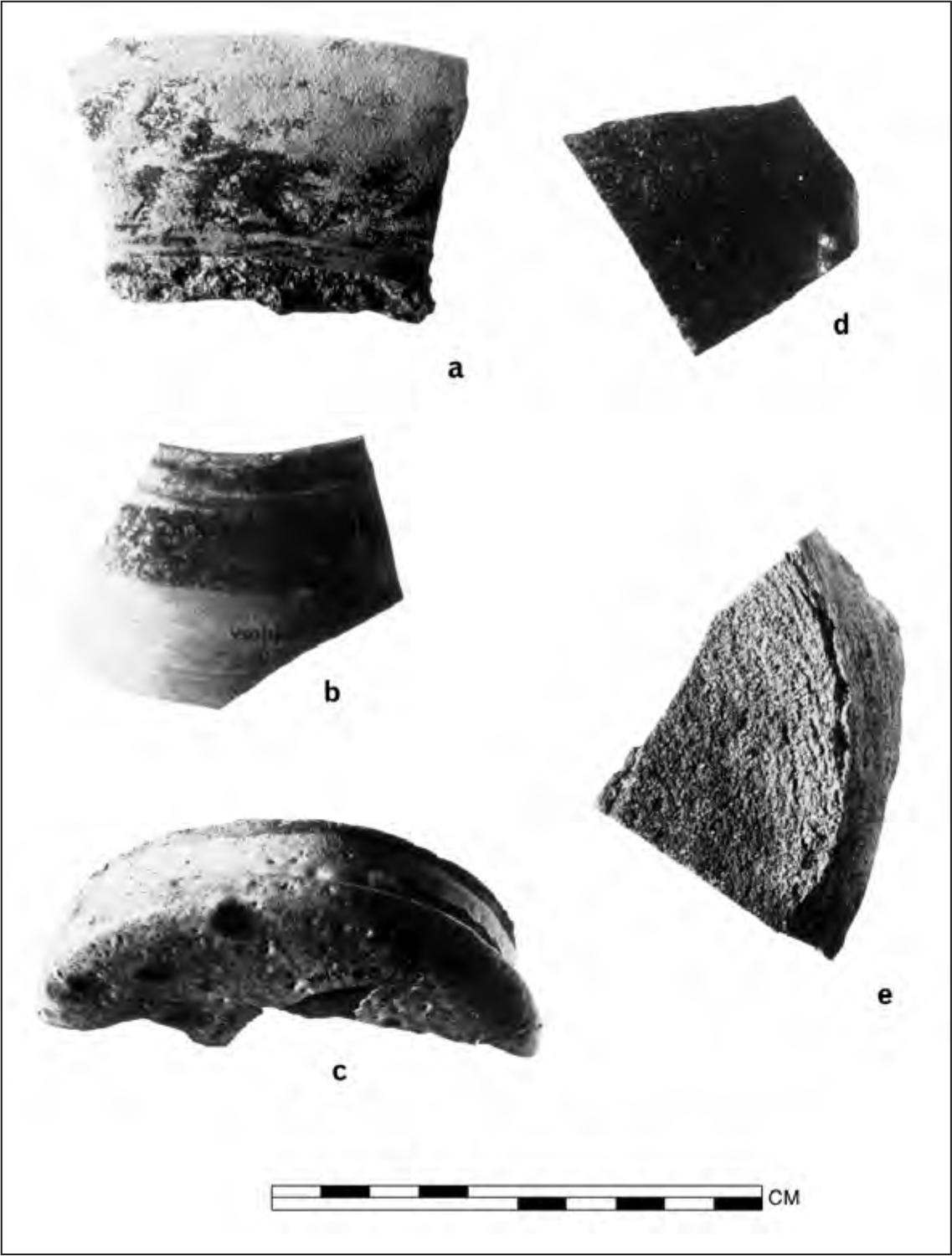 A black and white photograph of pottery shards. They all seem to have rough surfaces.