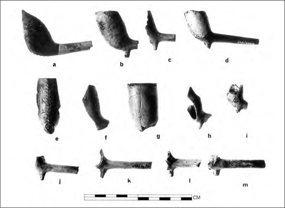 A black and white photograph of 13 broken clay pipes.