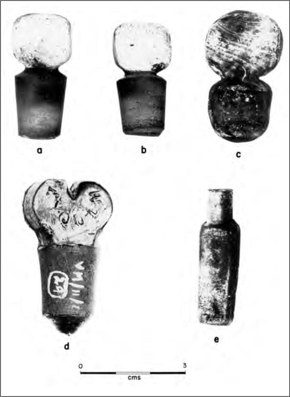 A black and white image of glass stoppers and a small glass phial.