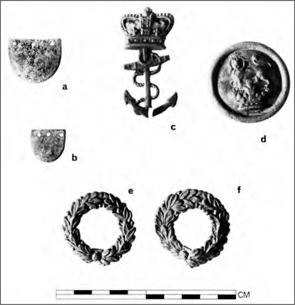 A black and white photograph of a Uniform insignia from Port Essington: copper ‘scales’ from epaulettes or shako chin straps, a crown and anchor naval insignia and a royal crest shako chin strap terminal.