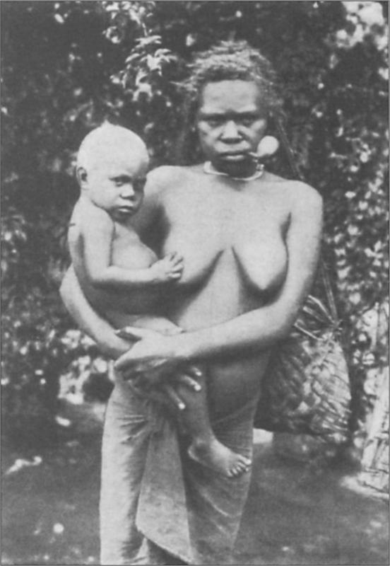 Black and white image of a mother with a child on her hip posing for the camera.