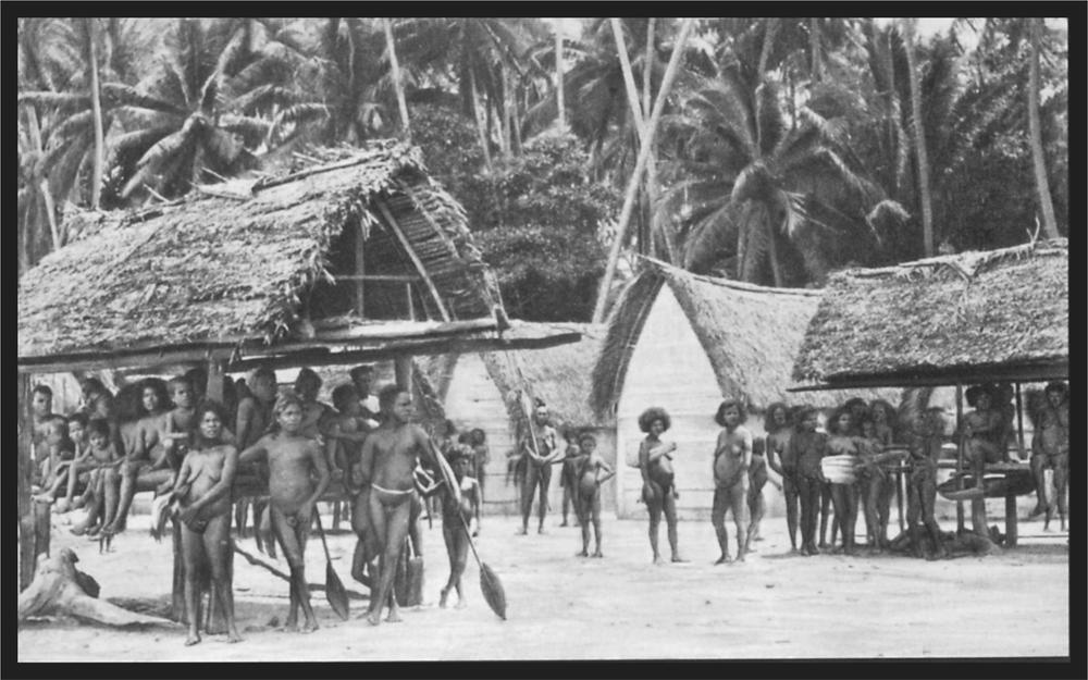 Black and white image of a group of people in their village around open style huts.