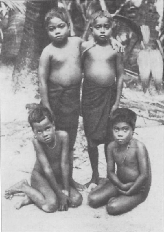 Black and white image of four children posing for the camera.