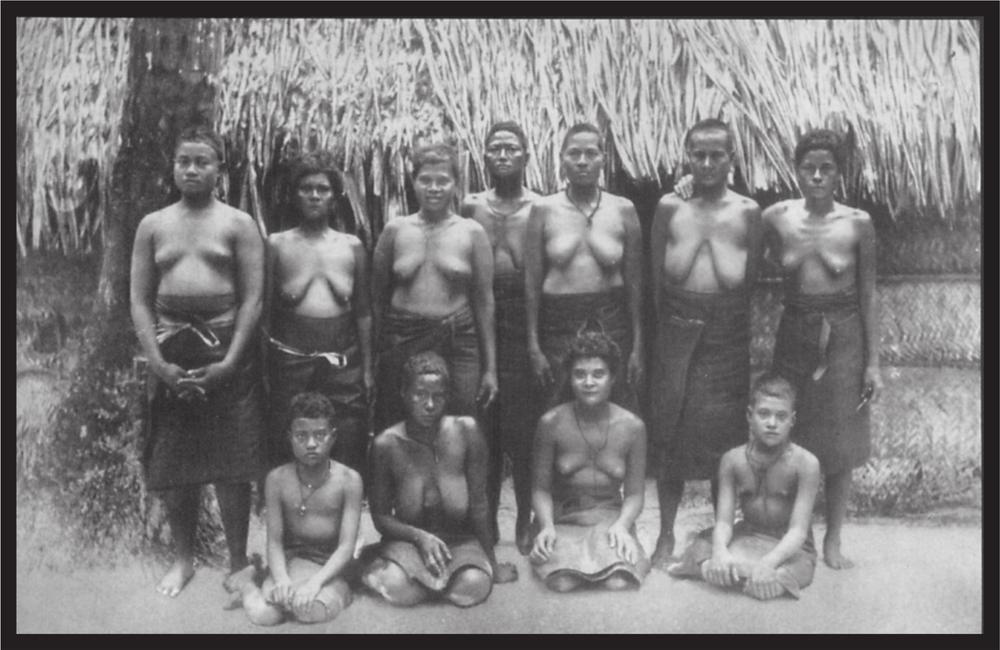 Black and white image of a group of women in front of a hut.