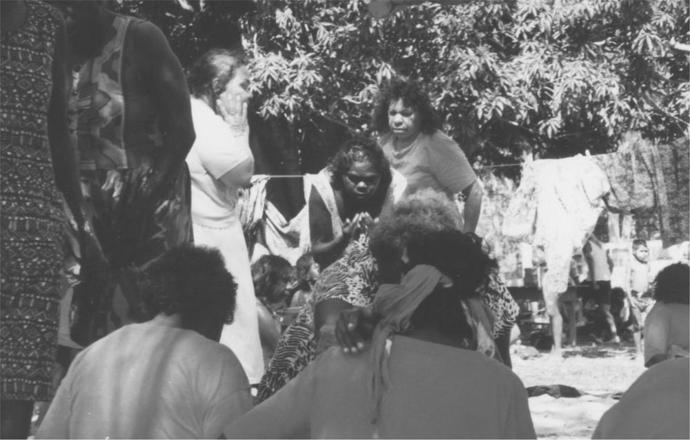 A black and white image of a ritual washing by mourners.