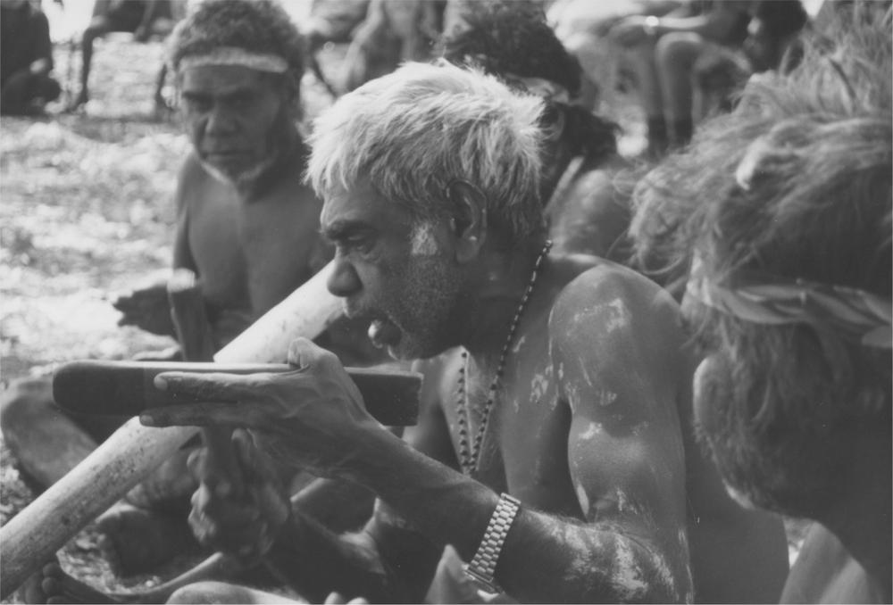 A black and white of Kenny Burrenjuck singing.
