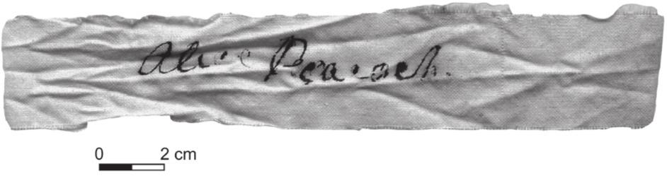 A black and white photograph of a cotton fabric with a name written in ink.