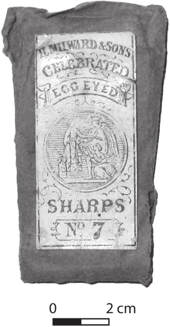 A black and white photograph of a needle packet with a white square logo. At the centre is a circle with three figures, one has wings. The bottom of the logo has: Sharps, no. 7.