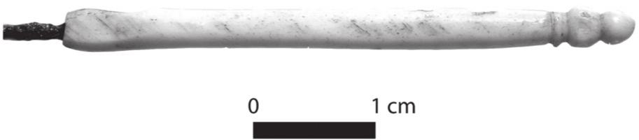 A black and white photograph of a bone handle of needlework tool.