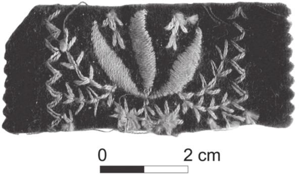 A black and white photograph of brown velvet embroidered with flower and leaf design.