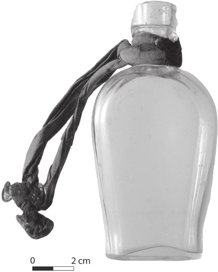 A black and white photograph of a flask bottle with a silk strap. 