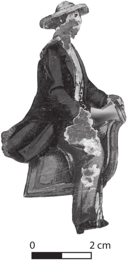 A black and white photograph of a toy figure wearing a coat and hat.