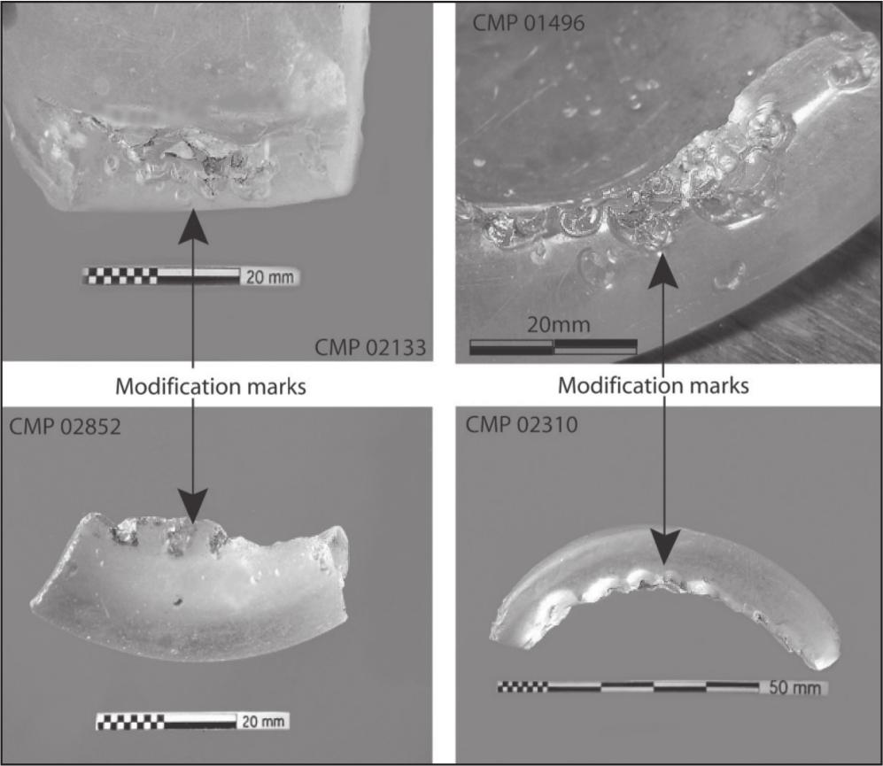 A black and white photograph showing four shards of bottle bases with indents.