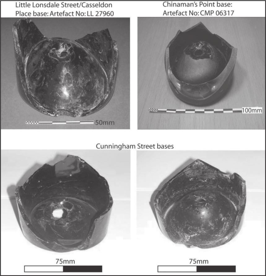 A black and white photograph of four broken bottle bases.
